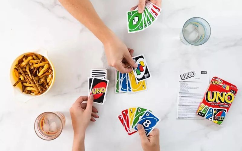 người chơi đánh bài uno trên bàn